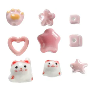 Assorted pink and white ceramic beads in cat, heart, and star shapes for DIY jewelry
