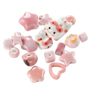 Detailed view of assorted pink ceramic beads with glossy cat, heart, and star shapes.