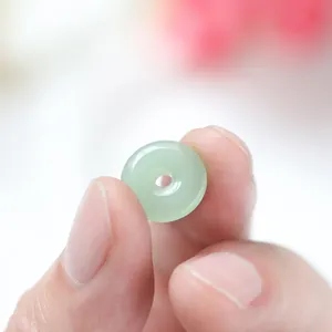 Makro-Detailansicht einer blassgrünen Glas-Ping'an-Kou-Perle für DIY-Schmuckhandwerk