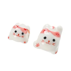 Detailed view of cute pink cat-shaped ceramic beads with a smooth creamy glaze texture.