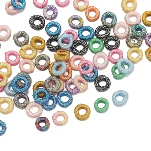 Close-up of colorful metallic thread woven rings for DIY jewelry making.