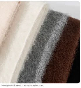 Primo piano di sciarpe in lana di alpaca pelosa in vari colori neutri.