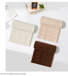 Vista dettagliata di sciarpe in lana di alpaca a pelo lungo in crema e marrone