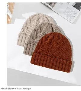 Drie stijlvolle gebreide wollen mutsen in beige, grijs en roestbruin voor de winter.