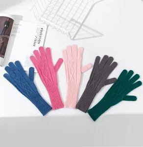 Detailansicht verschiedenfarbiger langer Strickhandschuhe aus Wolle mit Zopfmusterdesign