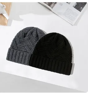 Detail van dikke gebreide mutsen van 100% wol in de kleuren minimalistisch grijs en zwart