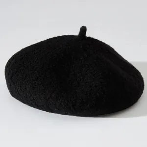 Detail view of a black fuzzy beret hat featuring soft plush texture for winter