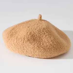 Close-up detail of the soft plush texture on a thick warm camel beret hat for women