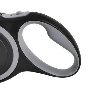 Detailed view of the ergonomic handle and brake button of an 8m black retractable dog leash rope