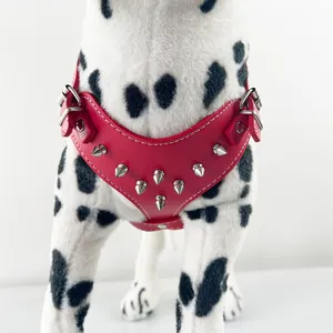 Close-up detail shot of a red PU leather dog harness featuring silver punk-style spikes
