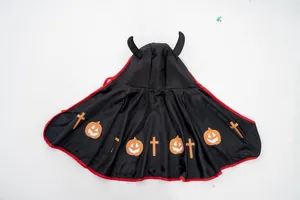 Primo piano della mantella di Halloween per animali con corna e zucche arancioni
