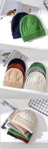 Dettaglio di berretti in maglia di lana con treccia e motivo a rombi in vari colori