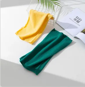 Detail view of yellow and green Merino wool neck gaiters on a white background