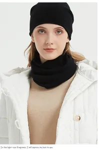 Model wearing a black 100% merino wool knitted neck gaiter and matching beanie set.