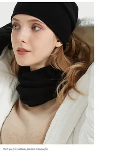 Detail of soft black merino wool neck gaiter and knit beanie worn by a female model.