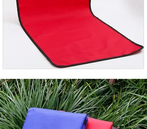 Détail de la housse de siège rouge en tissu Oxford pour animaux et tapis pliés sur l'herbe