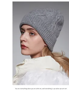 Primo piano di un berretto di lana grigio a maglia con eleganti motivi a treccia.