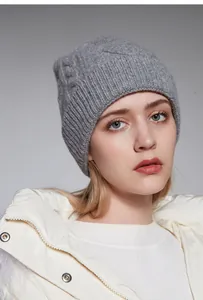 Primo piano del berretto in lana grigia con motivo a trecce classico su modella