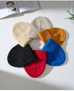 Nahaufnahme von bunten gestrickten Wollmützen, im Kreis auf dem Tisch