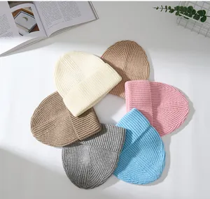 Mehrfarbige, dicke Wollstrickmützen, die in einem Kreis zur Präsentation angeordnet sind.