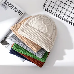 Pila di cappelli colorati in lana a trecce con motivi a rombi per il calore invernale