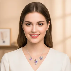 Detail eines weiblichen Models mit eleganter lila Zirkon-Herz- und Schmetterlingskette.