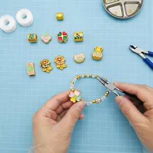 Close-up of DIY jewelry making featuring gold alloy blessing charms and koi fish beads