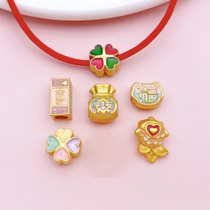 Close-up of golden alloy DIY jewelry charms with colorful enamel and lucky Chinese symbols