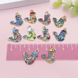 Detailed view of colorful ethnic bohemian bird alloy enamel charms with a ruler for scale