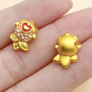 Detail view of golden koi fish charms showing enamel scales and plain back side.