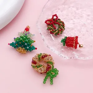 Detailed view of handmade beaded Christmas charms including tree and wreath motifs.