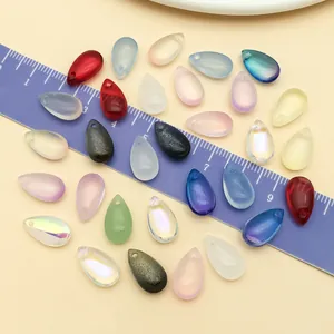 Detailed view of iridescent teardrop glass beads with ruler for DIY jewelry making size reference