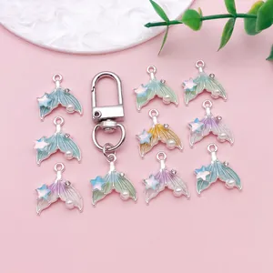Vista detallada de colgantes de cola de sirena con perlas y estrellas para manualidades DIY