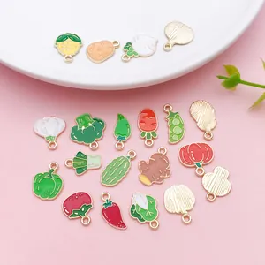 Variety of colorful enamel vegetable charms for DIY jewelry making on pink background