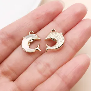 Detail view of two dolphin charms with pearlescent inlay and gold texture