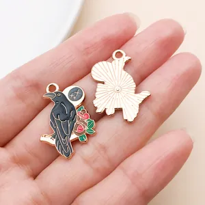 Gros plan d'un pendentif d'oiseau en alliage avec bordure dorée montrant l'avant et l'arrière