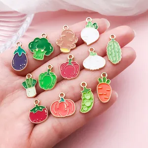Close-up detail of colorful vegetable enamel charms held in a person's palm for DIY jewelry
