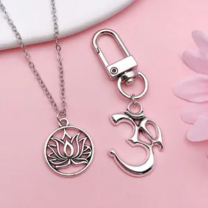 Vue détaillée du pendentif lotus et du porte-clés yoga symbole Om en argent