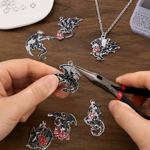 Detailed close-up of dark style dragon charms being used for DIY jewelry making.