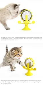 Primer plano de un gatito jugando con un juguete comedero lento de molino de viento.