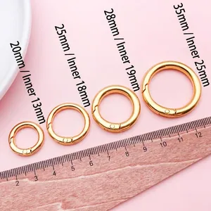 Detailansicht goldener Karabinerringe in verschiedenen Größen mit einem Lineal.