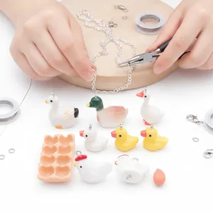 Close-up of DIY farm animal charms and jewelry making tools for handmade crafts
