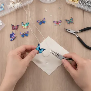 Detailed view of DIY necklace assembly using colorful alloy butterfly charms and pliers.