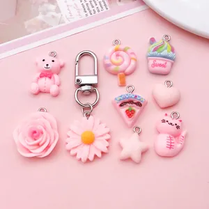 Gedetailleerde weergave van schattige roze hars bedeltjes in diverse vormen voor DIY-projecten.