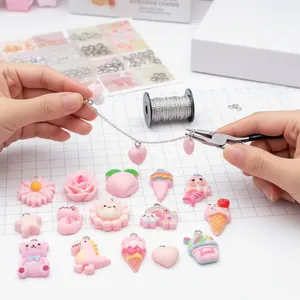 Close-up van het maken van DIY-sieraden met verschillende roze harsbedels en een tang