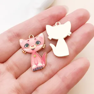 Close-up of pink cartoon cat enamel charms showing front and back for DIY jewelry.