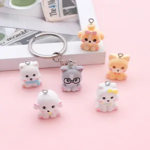 Detailed view of several cute cartoon dog charms with a metal keychain on pink background