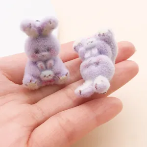 Gros plan détaillé de la texture floquée douce de ces breloques lapin parent-enfant mauves