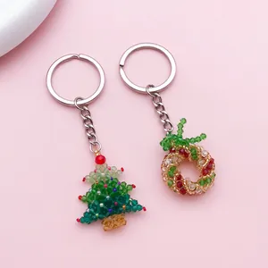 Detail of handmade beaded Christmas tree and wreath keychains with colorful crystals.