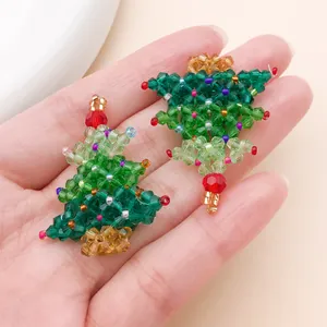 Close-up of handmade beaded Christmas tree pendants with colorful crystal beads.